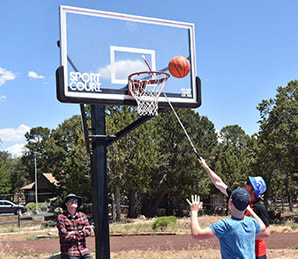 An athlete tries for a basket with adaptive assistance.